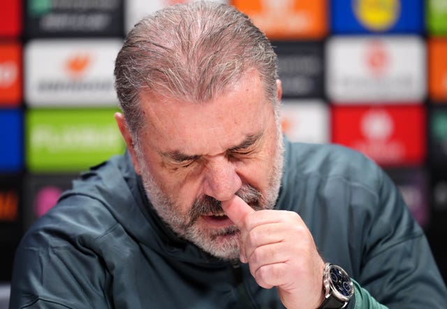 Ange Postecoglou closes his eyes and itches his nose during a press conference