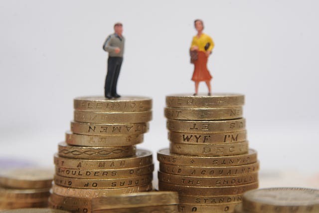 Models of a man and woman, each position on top of a pile of £1 and £2 coins