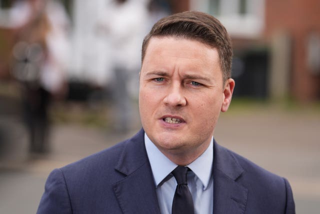 Wes Streeting speaking, dressed in suit and tie