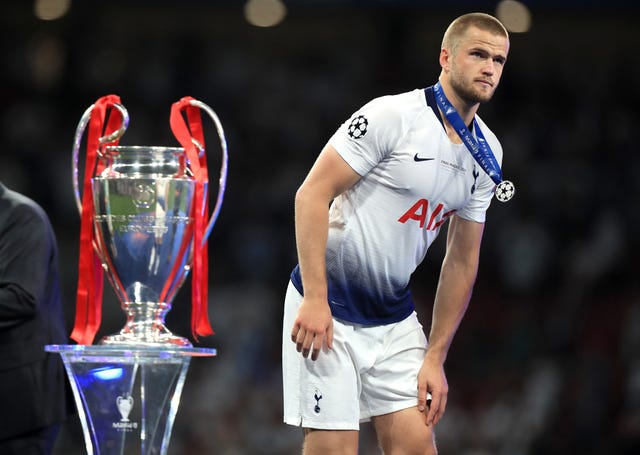 Eric Dier walks past the Champions League trophy wearing his runner-up medal