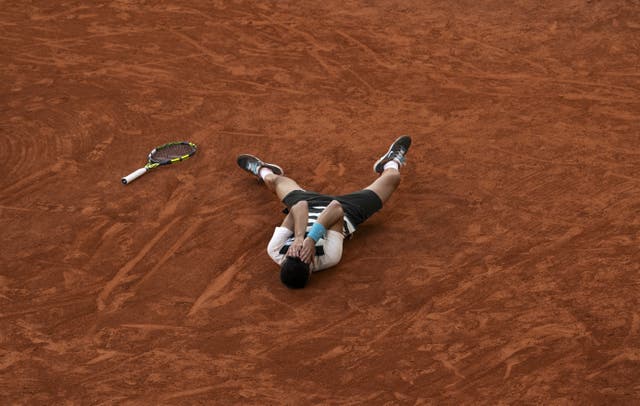 Carlos Alcaraz lies on the clay