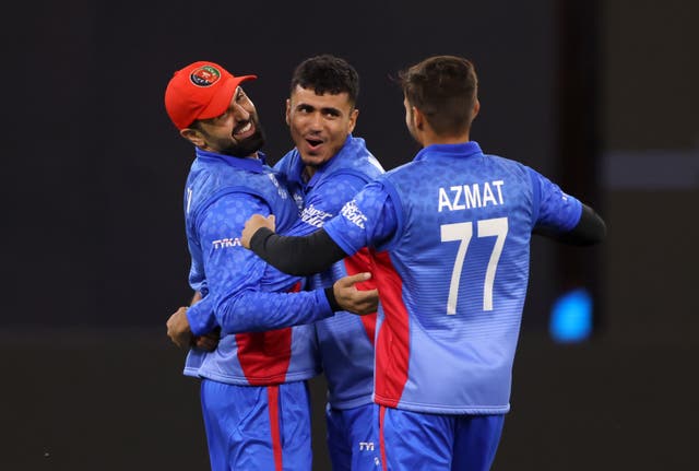 Afghanistan bowler Mujeeb Rahman, centre, celebrates taking the wicket of England batsman Dawid Malan, not pictured
