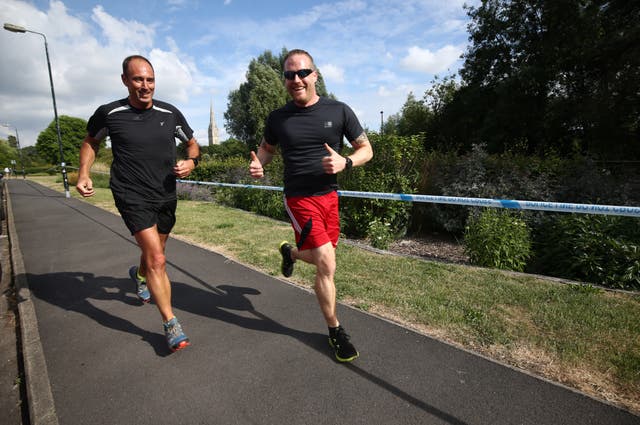 Joggers pass a police cordon around Queen Elizabeth Gardens in Salisbury 