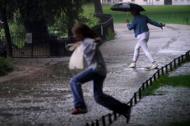 Two women jump over a flooded path in St James’s Park in central London last month