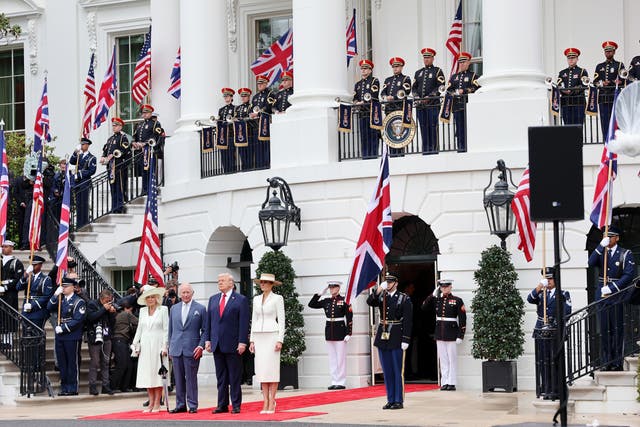 Soldiers bearing flags and the King Queen and President at the White House 