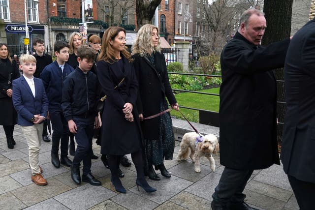 Charlie Bird’s wife Claire with his dog Tiger follow his coffin as it arrives for a service at Mansion House in Dublin to celebrate the life of the former RTE correspondent who died on Monday