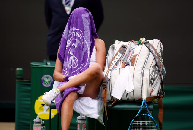 Clara Burel sits with her towel covering her face