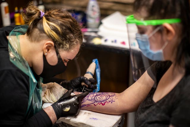 Tattoo artist Catherine Amos (left) tattooing customer Maria Speers at Belfast City Skinworks