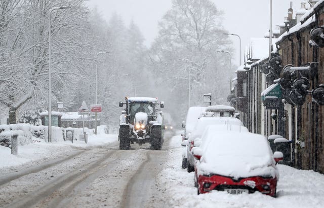 A tractor makes its way through snow in Braco, near Dunblane, in Scotland