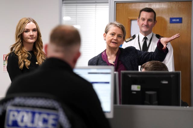 Yvette Cooper gestures to a police officer 