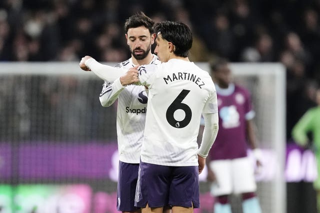 Manchester United’s Bruno Fernandes (left) passes the captains armband to Lisandro Martinez