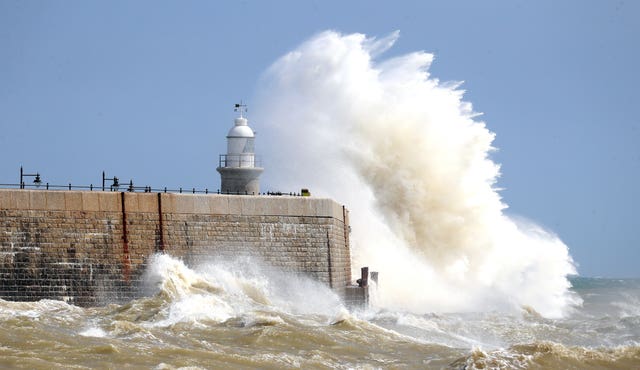 Waves crash over the harbour wall in Folkestone, Kent, on August 21