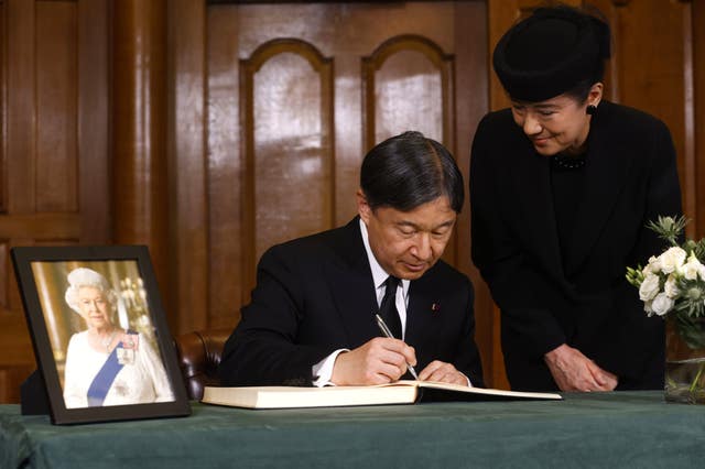 Emperor Naruhito and his wife, Empress Masako, signing a book of condolence for Queen Elizabeth II 