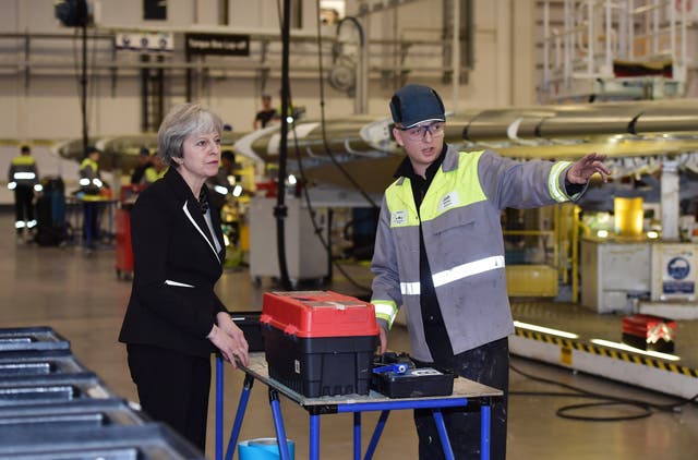 Theresa May speaks to a worker during a visit to the Bombardier factory (Charles McQuillan/PA)