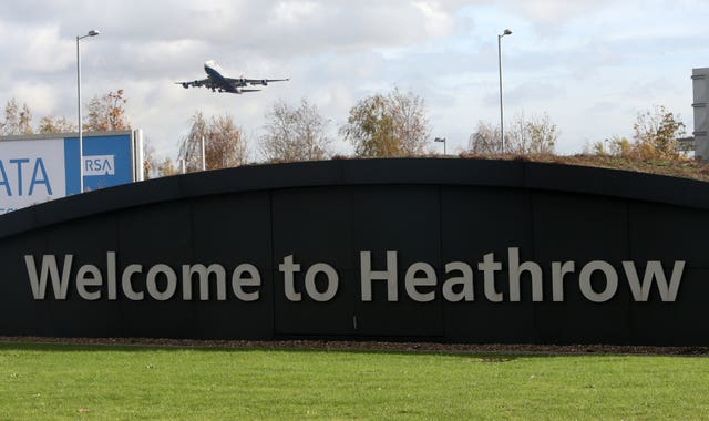 A BA plane takes off, with a Heathrow sign in the foreground