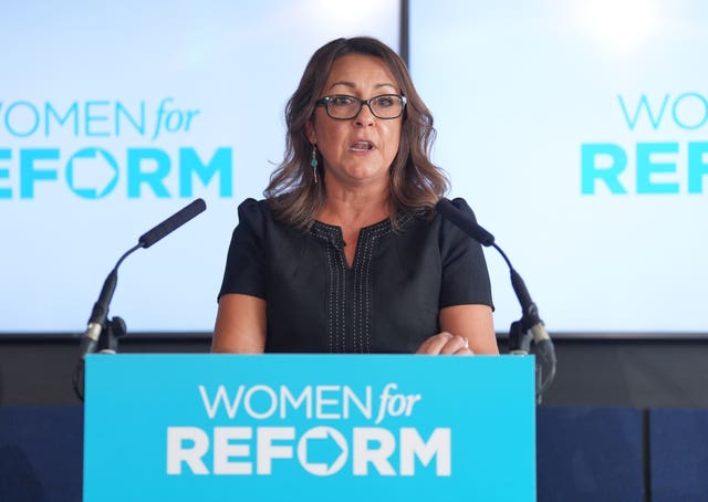 Linden Kemkaran speaking from behind a lectern that reads 'Women for Reform'