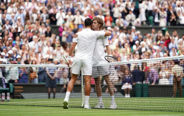 Novak Djokovic, left, and Andrey Rublev embrace at the net 