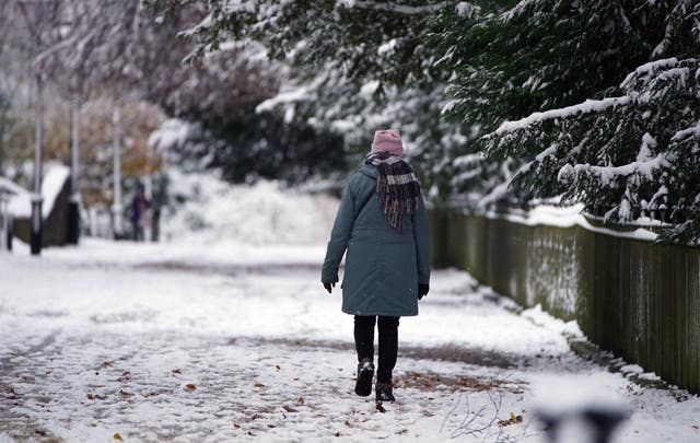 A person walks along a snowy street