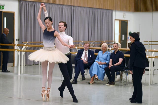 A group of people watch a ballerina on tiptoe