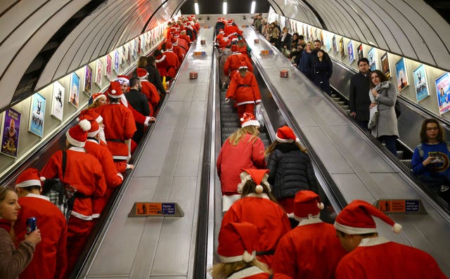 People in Santa costumes on escalator
