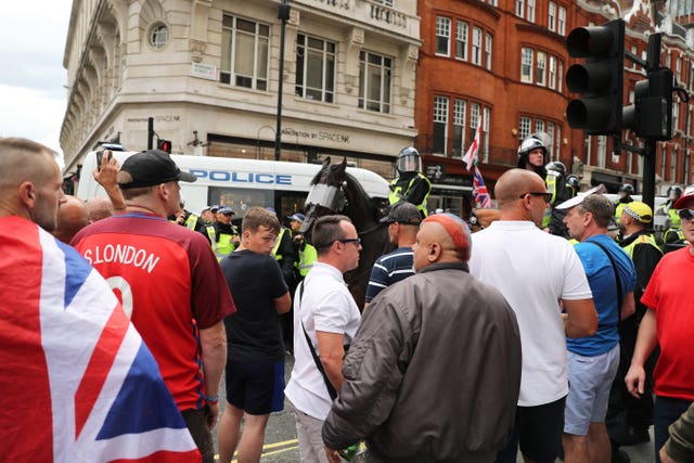 Tommy Robinson supporters are watched by police