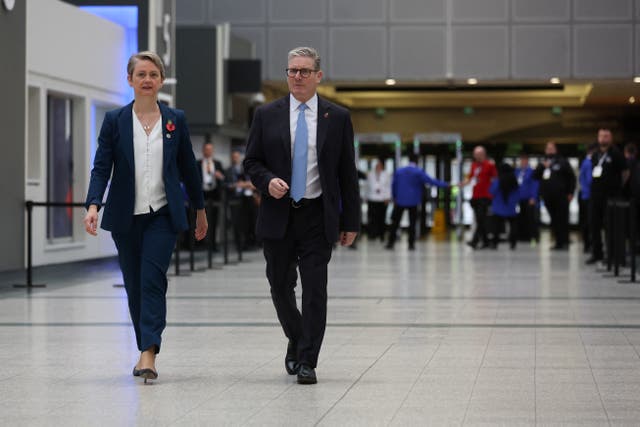 Keir Starmer and Yvette Cooper walk down a wide hallway at the Interpol conference in Glasgow.