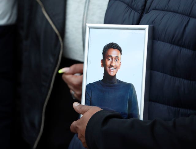 Mr Daniel's father holds a photo of his son at a vigil on Thursday (Steve Parsons/PA)