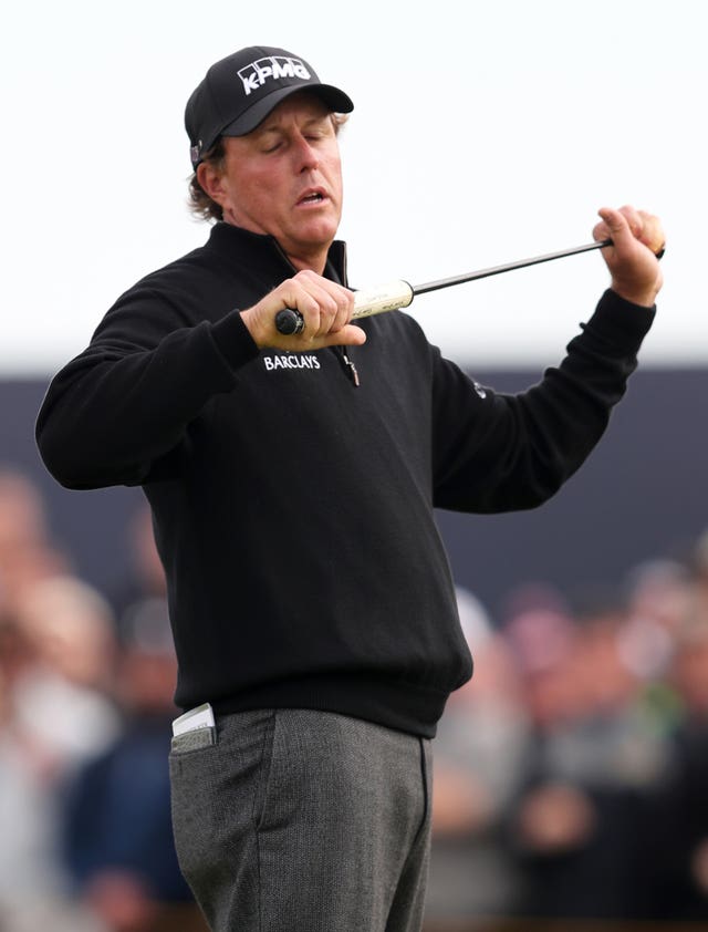 Phil Mickelson grasps his putter after a missed putt