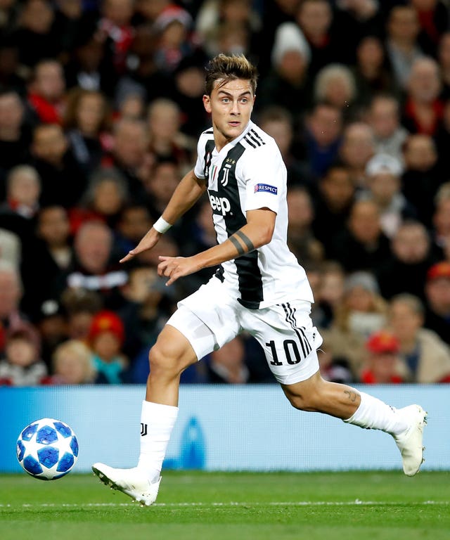 Paulo Dybala runs with the football in front of his right boot