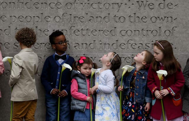 Children wait to place an Easter Lily, a symbol of the 1916 Easter Rising (Brian Lawless/PA)