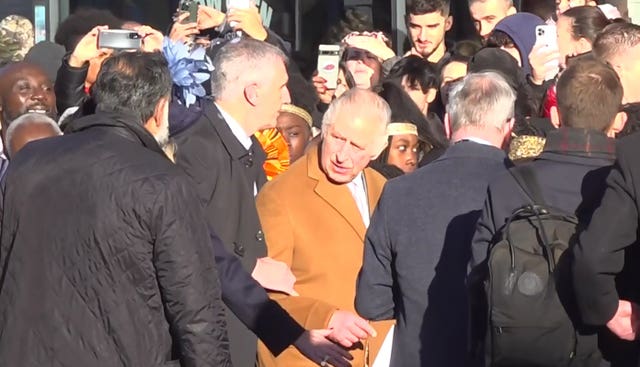 Screen grab taken from PA Video of close-protection officers ushering King Charles away from the crowd as he was meeting members of the public during a visit to Luton