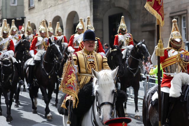 Mounted members of the military travel through Edinburgh