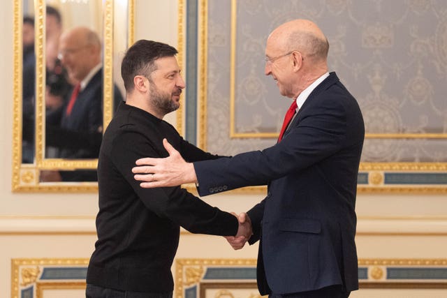Volodymyr Zelensky and John Healey shake hands