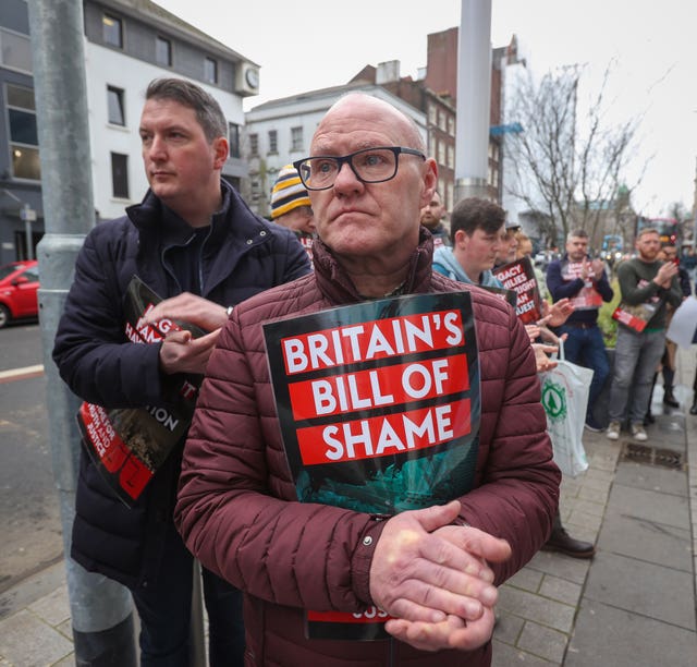 Sinn Fein MPs Paul Maskey, right, and John Finucane applaud a protest speech outside the Northern Ireland Office (NIO) at Erskine House in Belfast