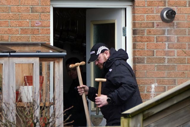 Police officer in the back garden of Nicola Sturgeon and Peter Murrell holding spades