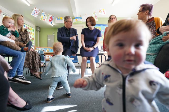 A toddler stands in the foreground as Sir Keir Starmer and shadow education secretary Bridget Phillipson chat to parents during a visit to Nursery Hill Primary School, in Nuneaton