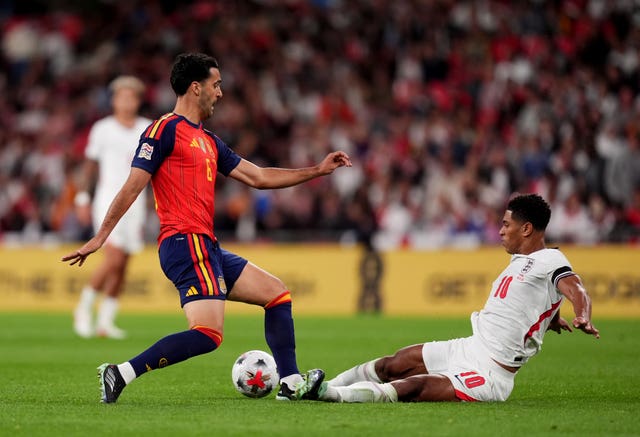 Jude Bellingham, right, battles for the ball with Mikel Merino