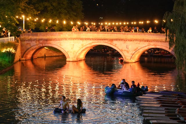 People in boats on the River Cam watch a firework display