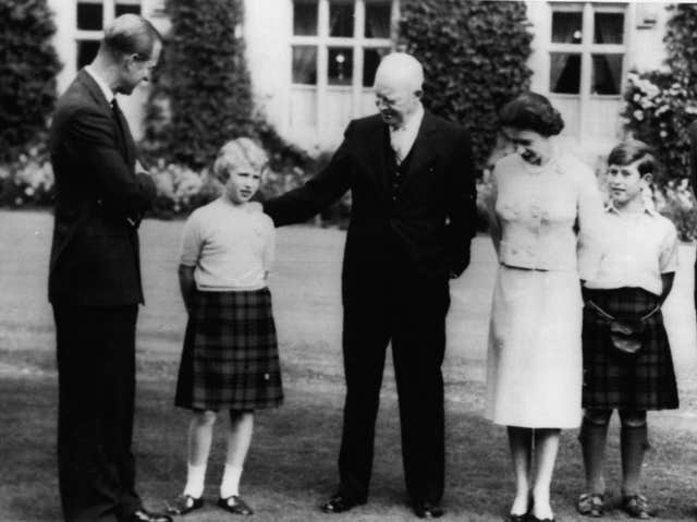 US President Dwight D. Eisenhower with his hand on a young Princess Anne's shoulder as he stands on the lawn with Queen Elizabeth II, Prince Philip and a young Prince of Wales at Balmoral Castle in 1959 