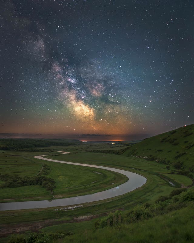 A winding road with the Milky Way stars above it 