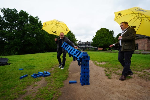 Liberal Democrats leader Sir Ed Davey and Liberal Democrat Parliamentary Candidate for Cheadle, Tom Morrison play Jenga during a visit to Cheadle, Greater Manchester 