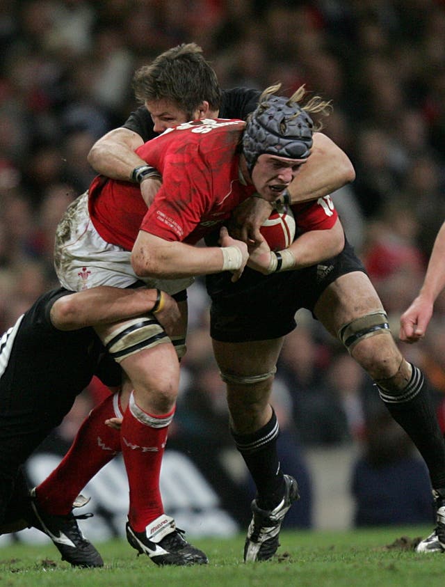 Alun Wyn Jones, left, is tackled by Richie McCaw