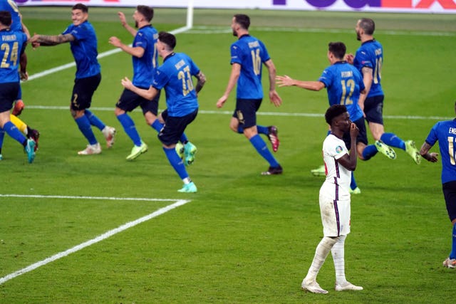Bukayo Saka stands dejected after missing from the penalty spot against Italy