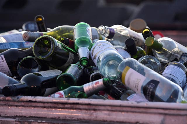 General view of a bottle bank overflowing at a recycling area in Brentford, London.