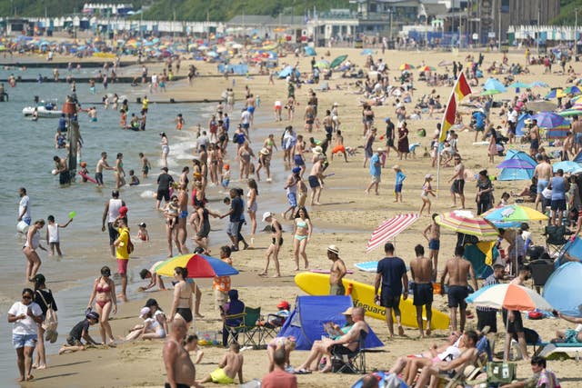 People relax in the hot weather on Bournemouth beach in Dorset (Andrew Matthews/PA)