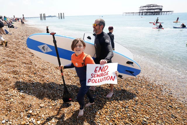 A young person holds up a placard as Surfers Against Sewage hold a protest in Brighton 