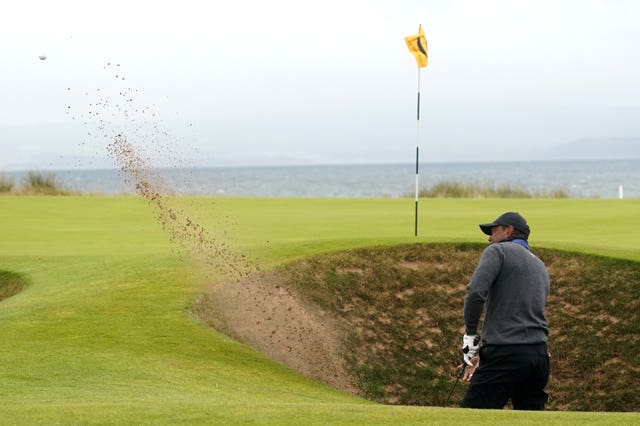 Tiger Woods chips out of a bunker during the first round of the Open at Royal Troon