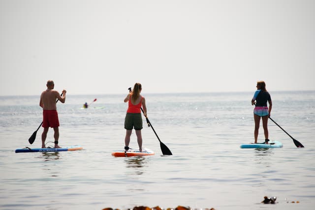 People on paddleboards in the sea in St Michael’s Bay in Cornwall