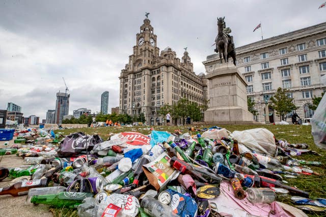 Workmen clear up rubbish left outside the Liver Building 