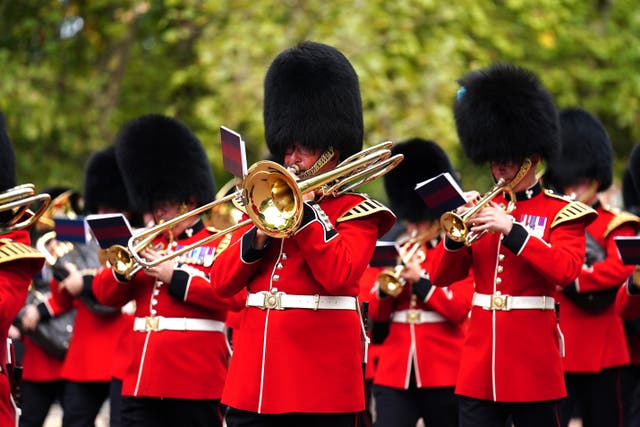 Members of the military band play during the funeral procession